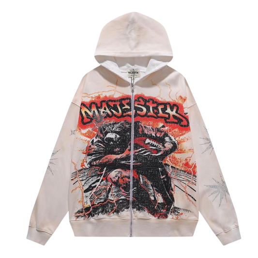 A cream-colored zip-up hoodie featuring a large graphic print of a wolf with the word 'MAJESTICK' in a red graffiti-style font across the chest.