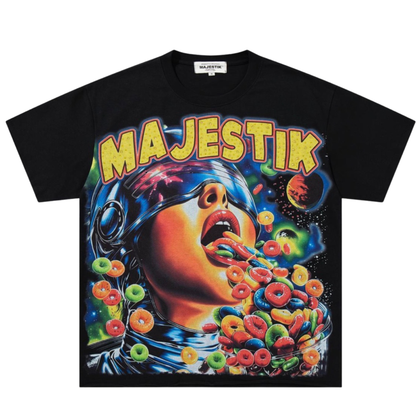 A black Majestik graphic t-shirt featuring a vibrant, colorful print of an astronaut vomiting cereal loops under the word 'MAJESTIK' in bold yellow letters.