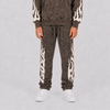 A person wearing a matching acid-wash brown hoodie and jogger sweatpants set with cream flame patterns down the sleeves and legs, paired with white sneakers, against a light gray studio background.